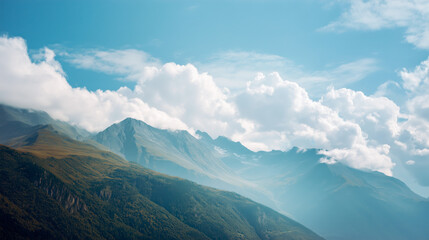 Fototapeta premium Scenic mountain landscape with rolling green hills under a bright blue sky and fluffy clouds