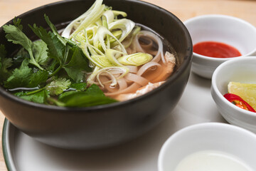 Vietnamese chicken pho with fresh herbs. Concept about tradition, culture and authentic cuisine.