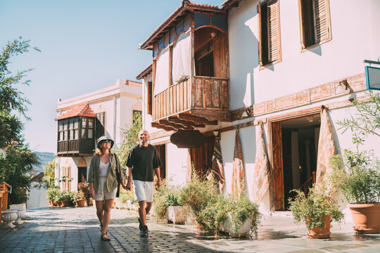 Middle aged couple walking hand in hand along narrow street in Kas town historical center. Romantic travel, love relationship, honeymoon vacation and happy retirement lifestyle concept.