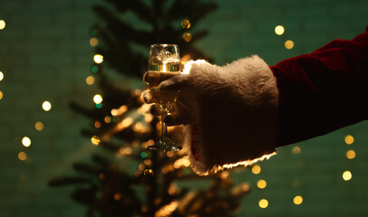 Santa Claus holding a champagne glass in front of a decorated tree, surrounded by festive lights...