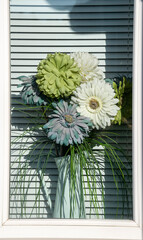 Dry floral bouquet in white metal watering jar.