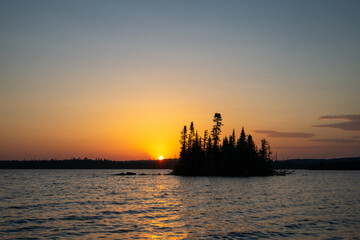Fototapeta premium silhouette of a small island against an orange sunset sky Ontario Canada