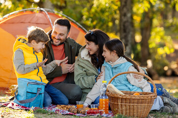 Family enjoys picnic in sunny park in autumn