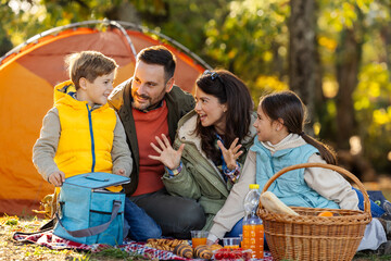 Family enjoys picnic in sunny park in autumn