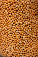 Close-up of dried yellow split peas filling the frame, showcasing their texture and natural color in a bulk food or pantry setting