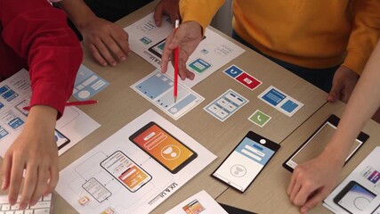Smart startup company employee group planning on user interface prototype for mobile application or website in office. Clever UX UI designer brainstorm designing user friendly interface plan. Synergic