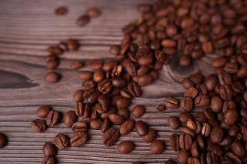 scattered aromatic coffee beans on textured wooden surface, highlighting rich brown hues and natural textures, evoking a sense of warmth, rustic charm, and indulgent relaxation, spread, finely