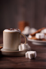 cozy scene with a ceramic mug of hot chocolate topped with chocolate shavings, surrounded by marshmallows, brownie bites, and warm lighting for a comforting atmosphere, autumnal, layered, mocha