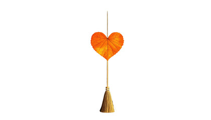 Heart-shaped autumn leaf atop a tassel on a black background, lit to highlight details
