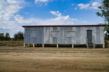 weathered corrugated metal railway shed in a rural landscape