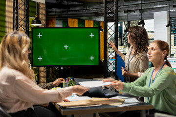 Team of goals oriented managers work with a chroma key screen on TV in a modern boardroom, hosting a business discussion with monthly reports insight. Company strategy for growth.