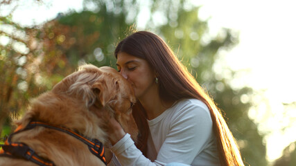 Woman showing affection to golden retriever dog