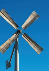 Close up view of large wooden windmill sails spinning slowly against a bright blue sky, symbolizing renewable power and clean energy ,historic ,wood ,outdoor