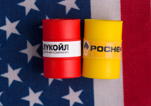 Moscow, Russia, 10.28.2025: A barrel of Lukoil and Rosneft oil against a US flag. Concept of sanctions against Russian oil.