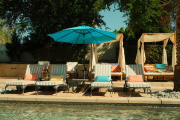 Aesthetic pool cabanas and lounge chairs basked in sunlight