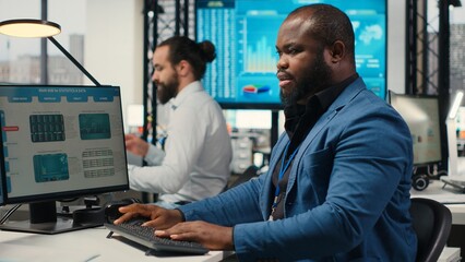 Black employee using data and technology for business management, reviewing statement graphs on...