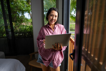 Middle eastern, asian woman managing her online banking, social life, and tasks on a laptop