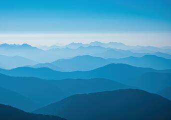 Obraz premium Scenic mountain range featuring hazy blue peaks stretching toward the horizon beneath a brilliant, cloudless sky ,daylight ,environment ,geography
