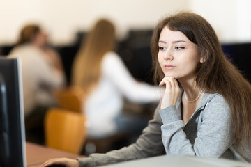 Obraz premium Portrait of young female student studying in university computer class