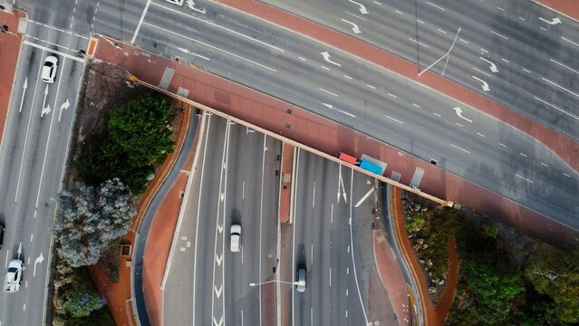 Traffic flows through an intersection with multiple lanes and road signs in a busy urban area