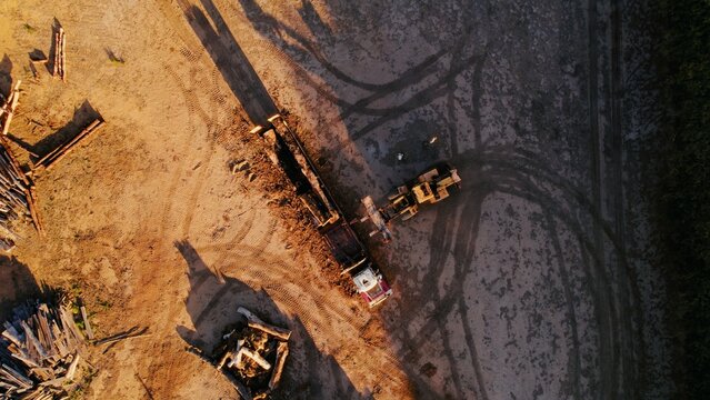 Construction site with heavy machinery in action during sunset hours creating new building foundations