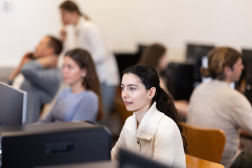 Portrait of female student at computers in university computer class