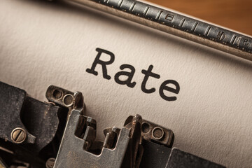 Close-up of the word &ldquo;Rate&rdquo; typed on paper with an old typewriter, symbolizing traditional finance, economic policy, and historical data analysis.