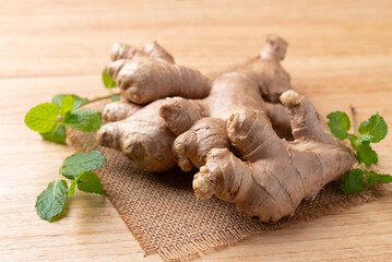 Fresh ginger with mint leaf on wooden background