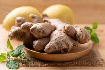 Fresh ginger and lemon on wooden background