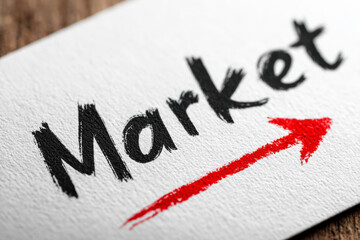 Close-up of the word &ldquo;market&rdquo; cut into a white fabric surface with a glowing green background, symbolizing sustainability, innovation, and eco-conscious business concepts.