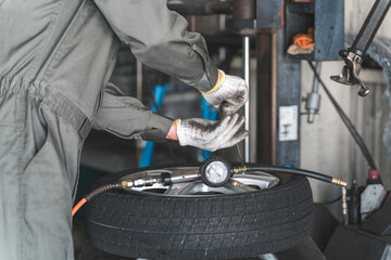 A male mechanic/service technician changes tires using a tire changer
