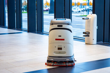 Autonomous cleaning robot operates on tiled floor inside modern building, demonstrating smart...