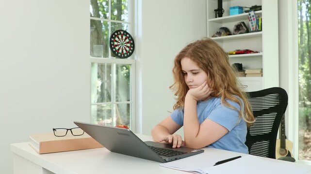 Child studying online with laptop. Focused student learning at home. Education and technology concept. Kid doing homework with concentration. Modern digital learning environment. - Powered by Adobe