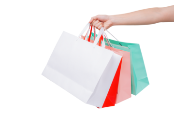 Hand holding several colorful empty paper bags on a transparent background.