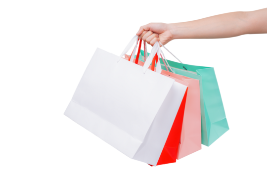 Hand holding several colorful empty paper bags on a transparent background.