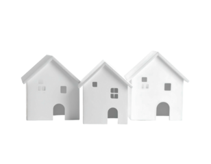 Three miniature white house models standing closely together against a stark black background