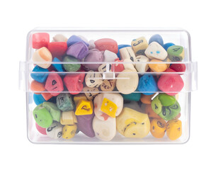 Transparent box filled with colorful, oddly shaped dice with numbers and spots visible inside against a white backdrop