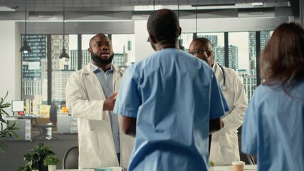 Medical staff in hospital office participating in a clinical discussion on diagnosis and treatment. Doctors and nurses analyze healthcare data and coordinate strategies. Camera B. - Powered by Adobe