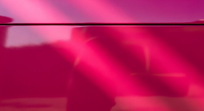 A glossy magenta surface with a dark line at the top and reflective light patterns