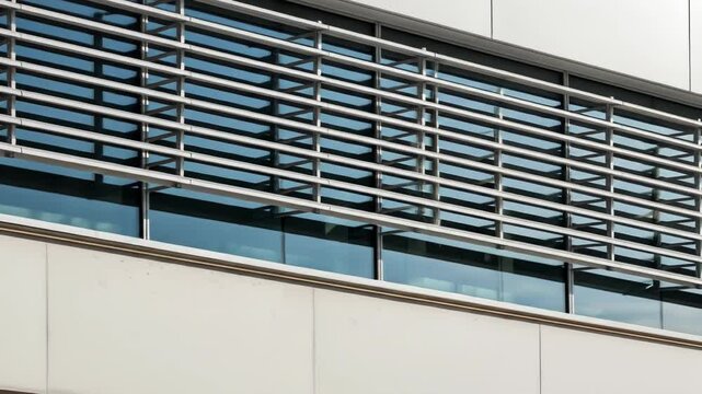 Modern building facade with metal sun shades over blue windows