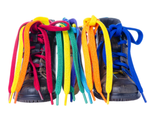 Two pairs of brown boots with vibrant rainbow colored laces, against a black background