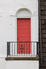 Traditional urban home with white brick wall and red painted door in Pittsburgh, USA.