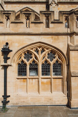 Fototapeta premium Elegant Gothic architecture with detailed stone carvings and arched windows bathed in warm sunlight, showcasing the timeless beauty of historical craftsmanship.