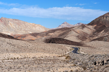 Mojave Desert highway north of Las Vegas, Nevada, USA, with barren landscape and cloudy sky, February 21, 2025.