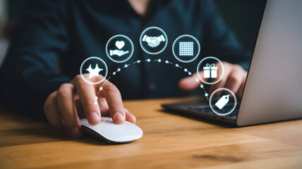 Person using a laptop with virtual icons representing business concepts such as charity partnership gift and loyalty program