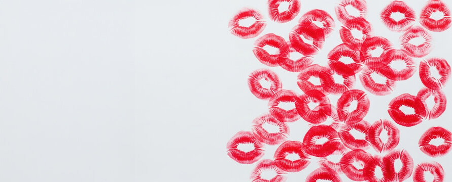 Several bright red lipstick kisses adorn the right side of clean, white surface, leaving plenty open space on left.Valentine's Day mood,copy space. Banner.