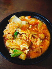 Tempting Bowl of Hot and Spicy Seblak with Mie and Mixed Ingredients Being Eaten