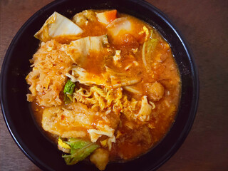 Delicious Traditional Javanese Cuisine Seblak with Orange Red Sauce and Noodles Lifted High