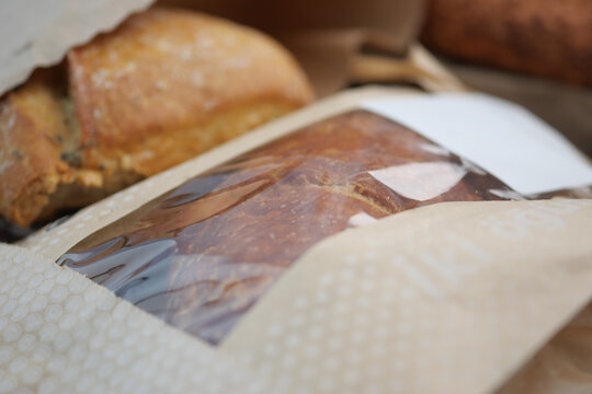 Freshly baked bread wrapped in paper at a bakery display