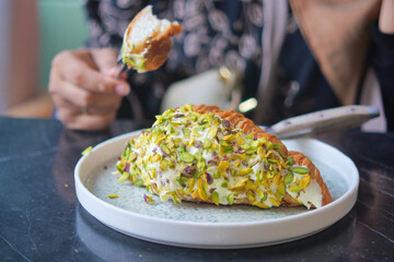 croissant topped with pistachios served at a cafe